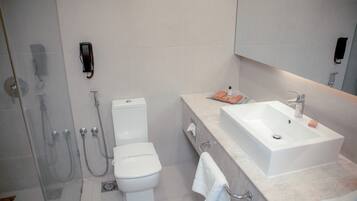 A modern bathroom with a toilet, shower, and sink.