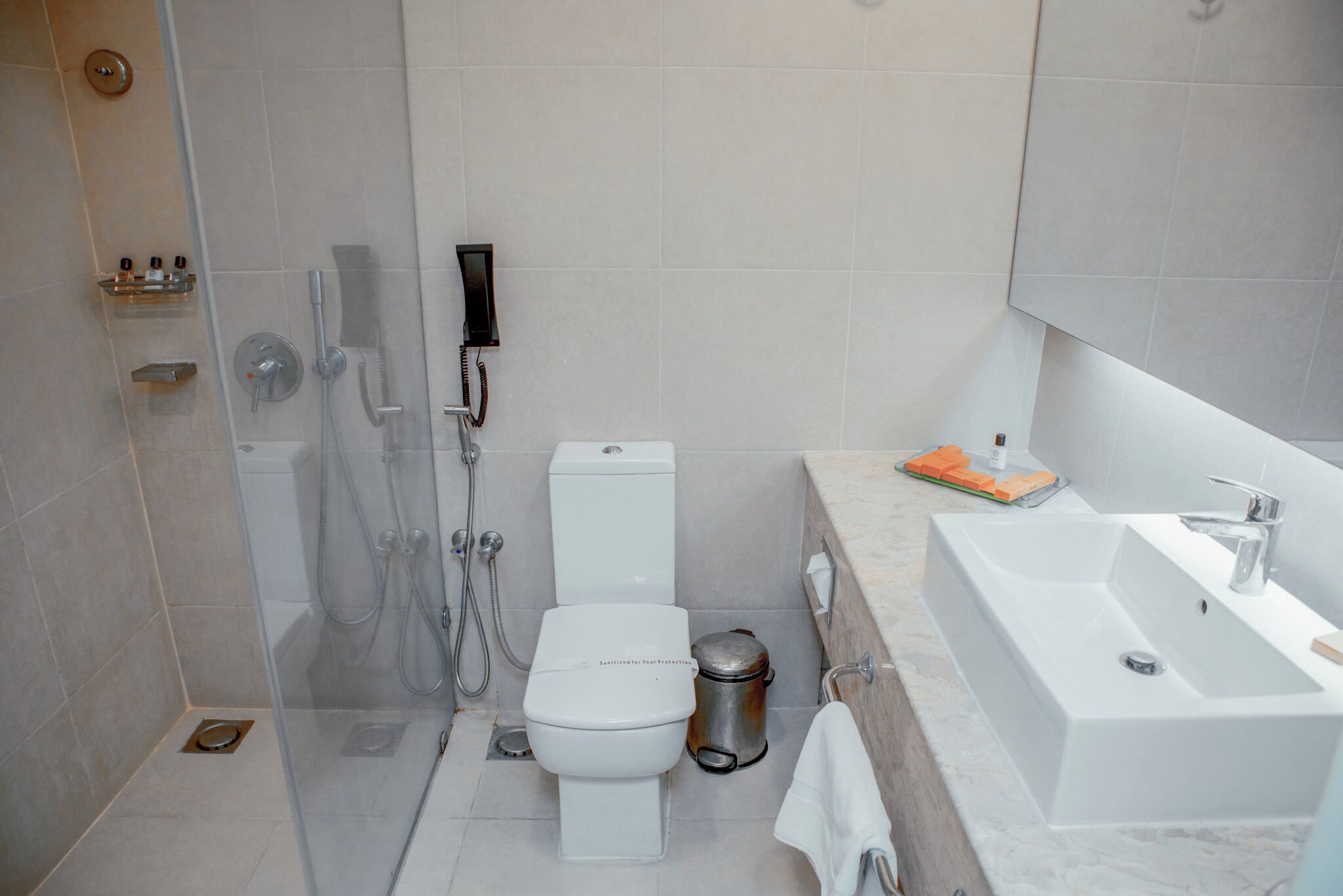 A modern bathroom with a toilet, shower, and sink.