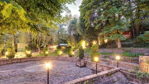A stone amphitheater surrounded by trees and illuminated by lights.