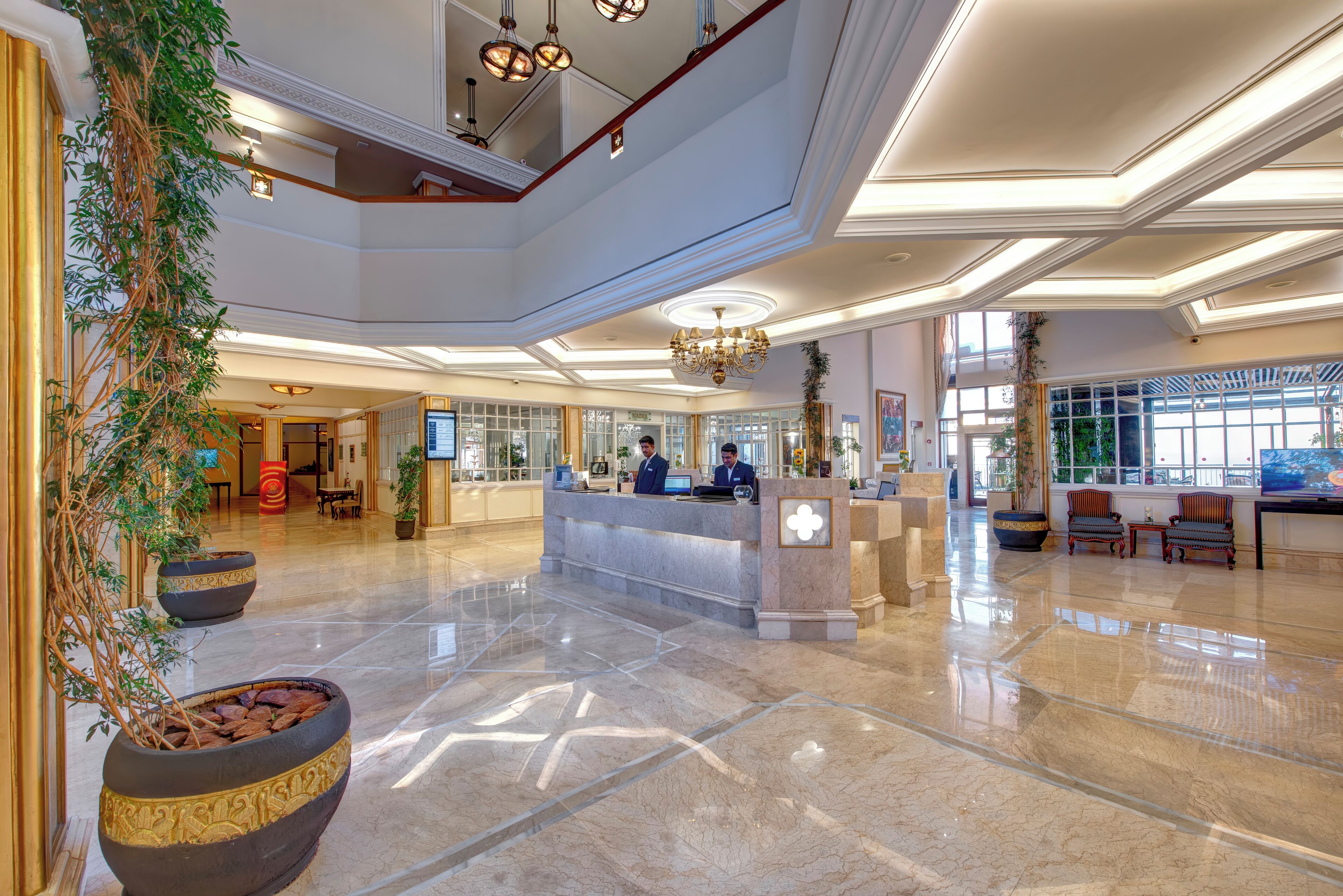A spacious lobby with a reception desk, seating area, and large windows.