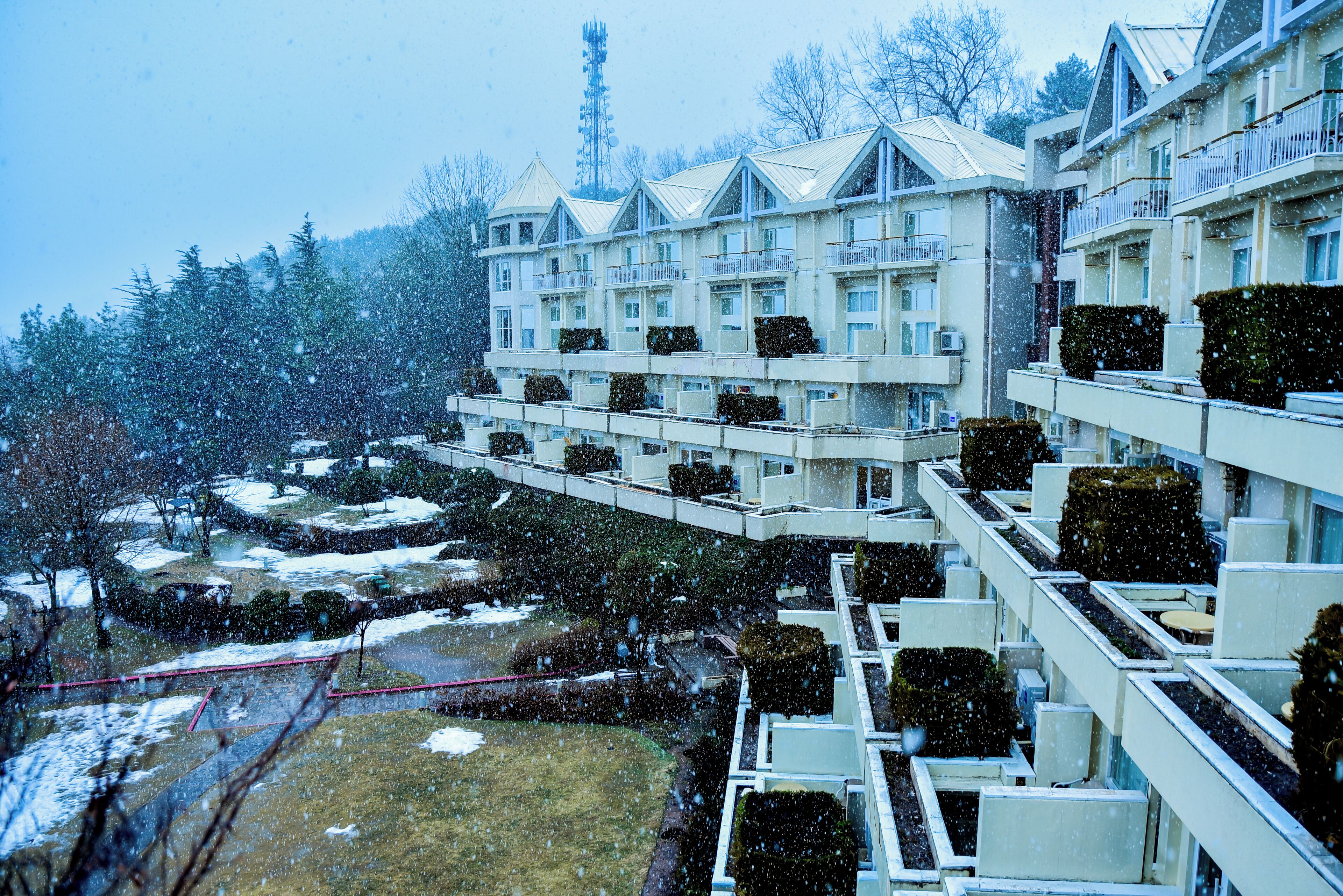 Un hotel de varios pisos con balcones y un paisaje cubierto de nieve.