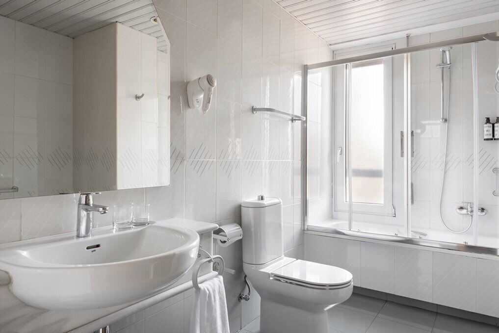 A modern bathroom with a large sink, toilet, and shower area.