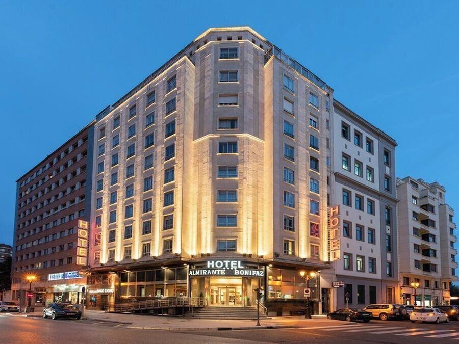 A multi-story hotel with a prominent entrance, large windows, and a well-lit facade.