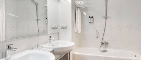 Ein modernes Badezimmer mit zwei Waschbecken, einer Badewanne und einer Dusche.