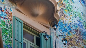 Une façade d’immeuble ornée d’un motif en mosaïque et dotée d’un balcon au design original.