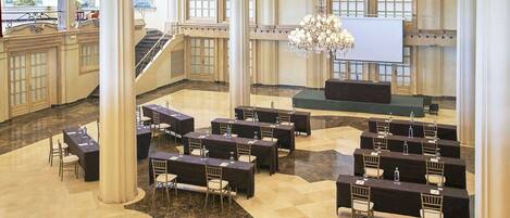 A spacious lobby with marble floors, multiple seating areas, and a large chandelier.