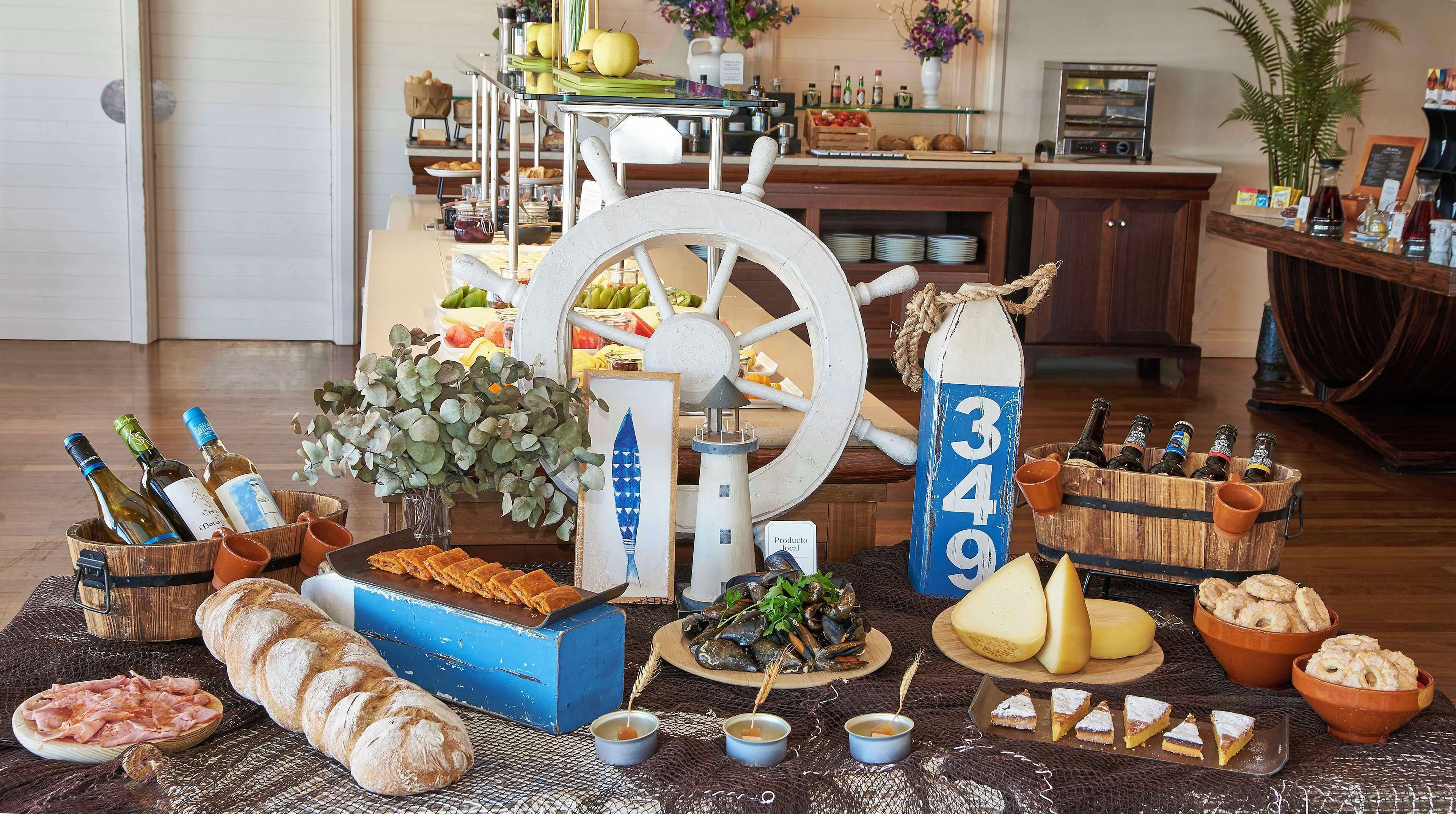 A dining area with a nautical theme, including a ship wheel, a lighthouse, and a bottle labeled '349'. There are various food items and drinks on the table.