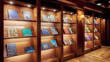 Una hilera de estanterías de madera con libros iluminados y una lámpara.