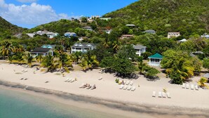 A beach resort with multiple villas, palm trees, and a sandy beach. - Oualie Beach Resort (Newcastle)