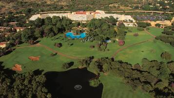 Experience golfing and relaxation amidst lush greenery and a serene lake.