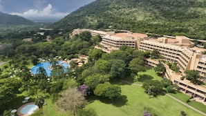 A resort with a large pool, lush greenery, and a mountainous backdrop. - Sun City Hotel and Casino (Moses Kotane)