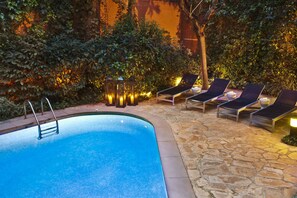 Una piscina al aire libre de temporada, tumbonas