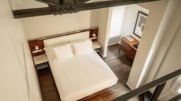 A bedroom with a bed, wooden headboard, nightstands, and a dresser.