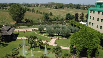 Stroll through the serene garden, featuring a central water feature and beautifully manicured hedges.
