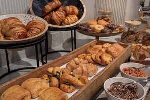 Una variedad de pasteles y productos horneados expuestos en mesas y cuencos.