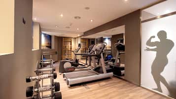 A gym with treadmills, dumbbells, and exercise balls.