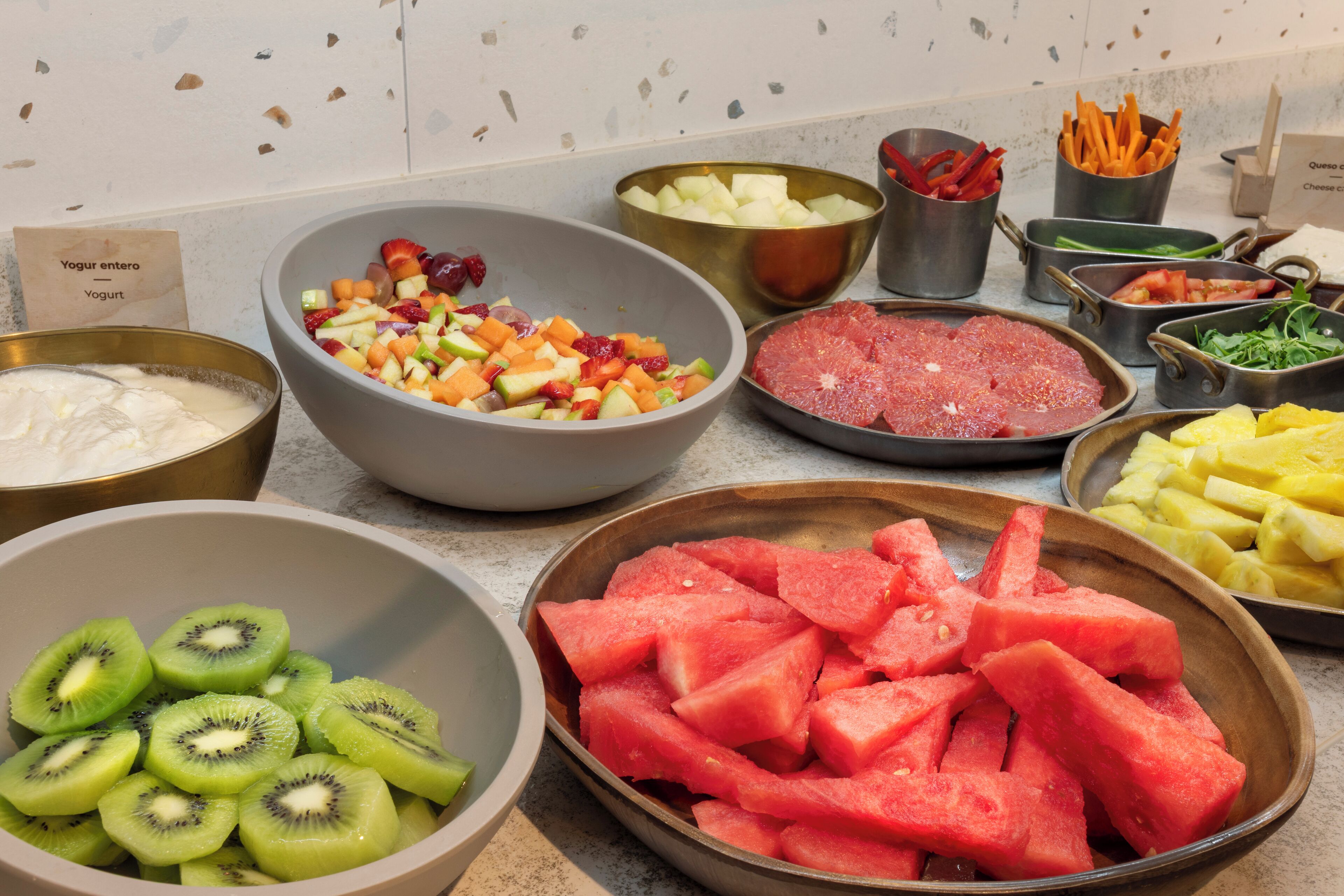 Una encimera de cocina con diversos alimentos, entre ellos frutas, verduras y carne.