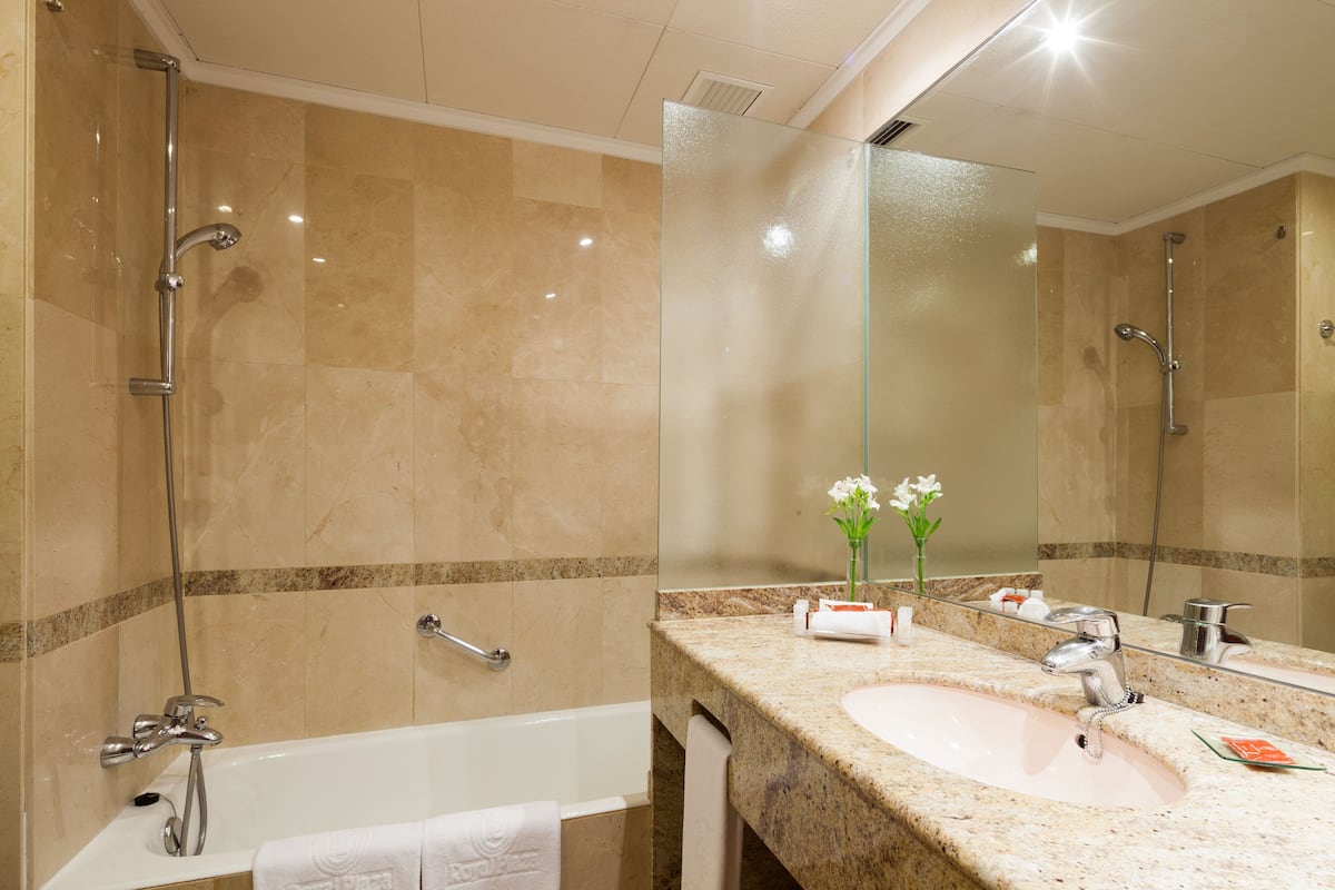 junior suite | bathroom | combined shower/bathtub, deep-soaking bathtub, free toiletries