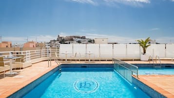 Una piscina al aire libre, tumbonas
