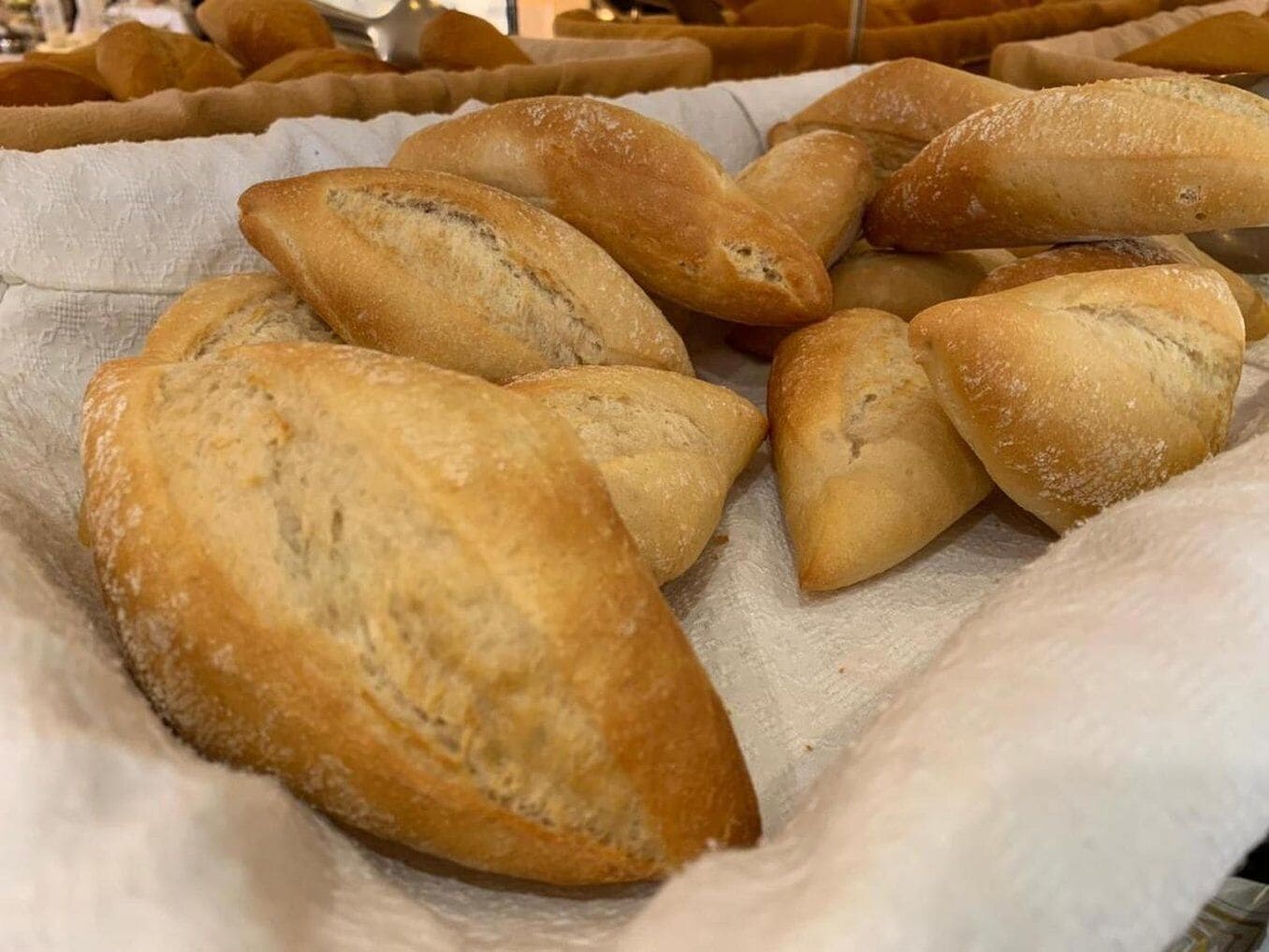 A variety of bread loaves on a cloth surface.
