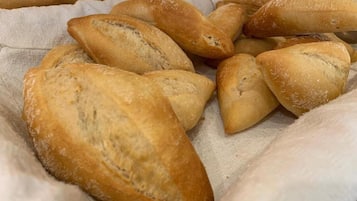 A variety of bread loaves on a cloth surface.