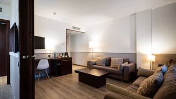 A modern living room with a sofa, coffee table, and a desk area with a chair.