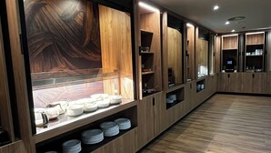 Una habitación de hotel moderna con piso de madera, estanterías empotradas con utensilios de cocina y un gran ventanal con vistas.
