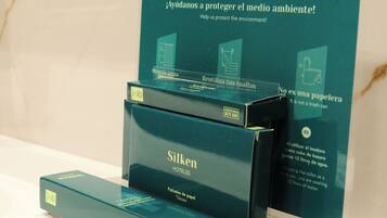 Presentatie van Silken Hotels producten met een bord dat milieubescherming promoot.