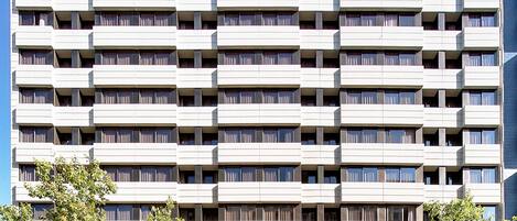 A multi-story building with a uniform facade, featuring balconies and windows.