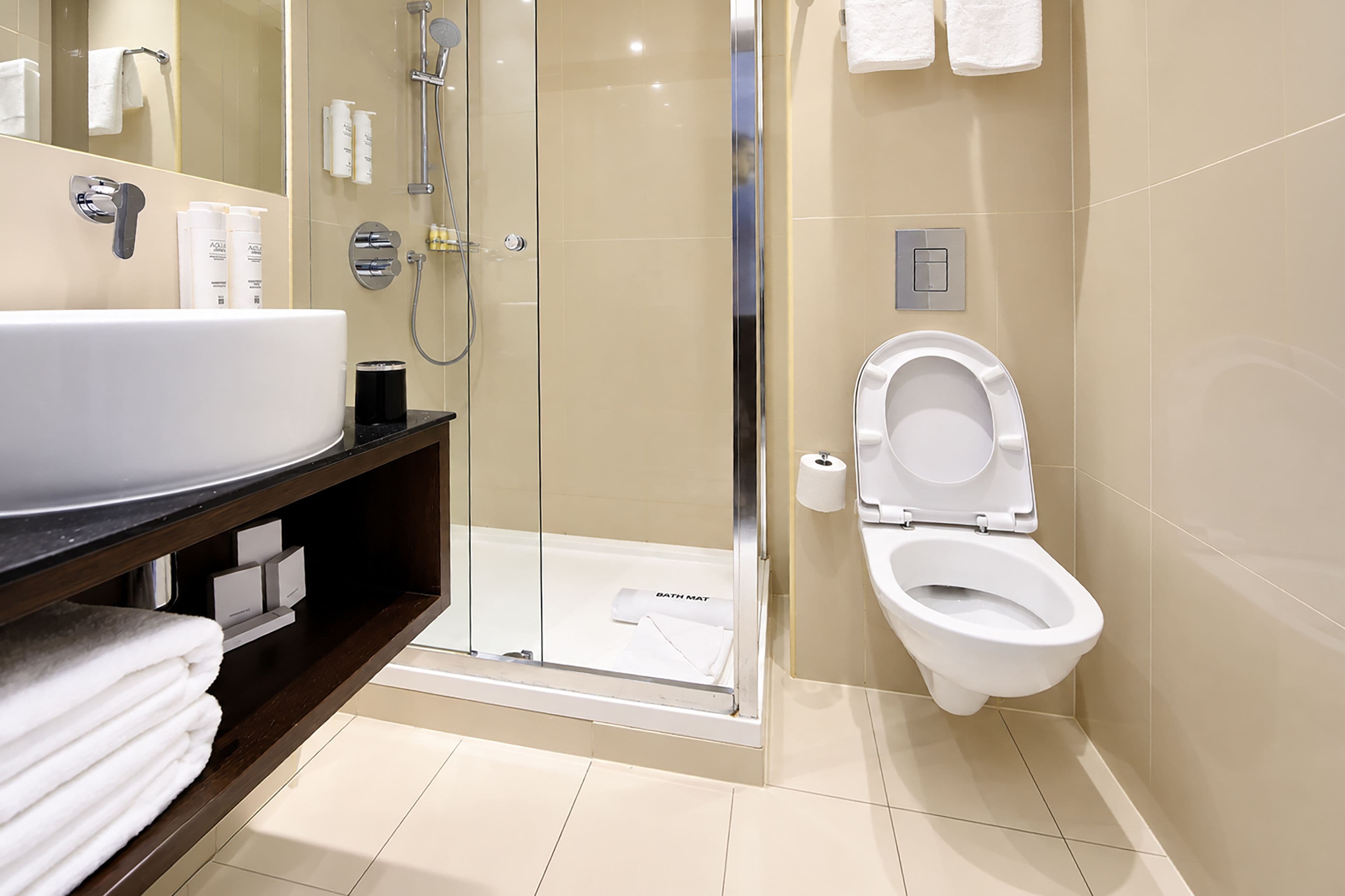 A modern bathroom with a large sink, toilet, and shower.