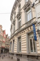 Un edificio histórico con detalles arquitectónicos ornamentales, incluyendo un letrero llamativo que dice 'The Gravensteen Hotel'.