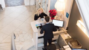 A reception desk with a computer, a lamp, and a sign indicating a hotel room. - Hotel Gravensteen (Ghent)