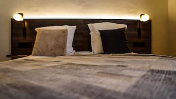 Un letto con una testiera, due lampade ai lati e una coperta.