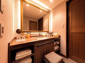 Une salle de bain moderne avec un meuble-lavabo en bois, un grand miroir et un porte-serviettes avec des serviettes.