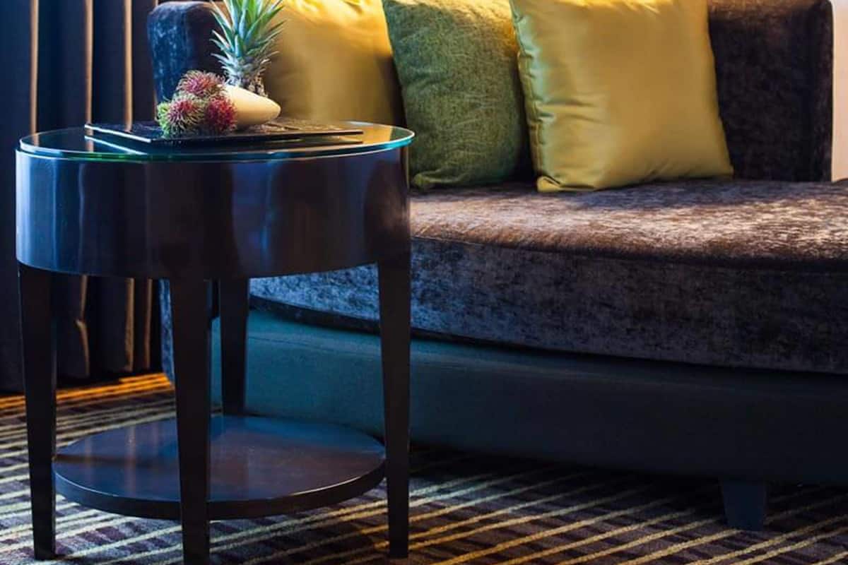A cozy room with a sofa, a lamp, and a small table with a pineapple decoration.