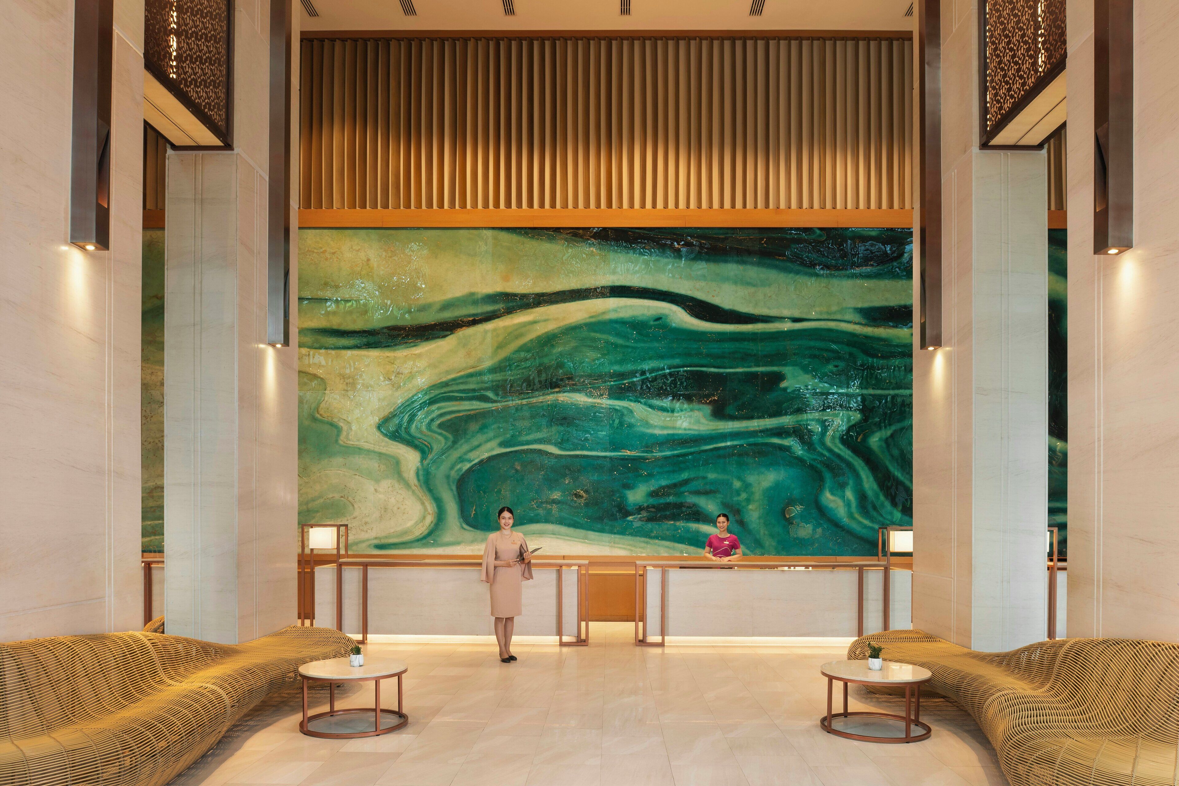 A reception area with a large abstract mural, two sofas, and a reception desk.