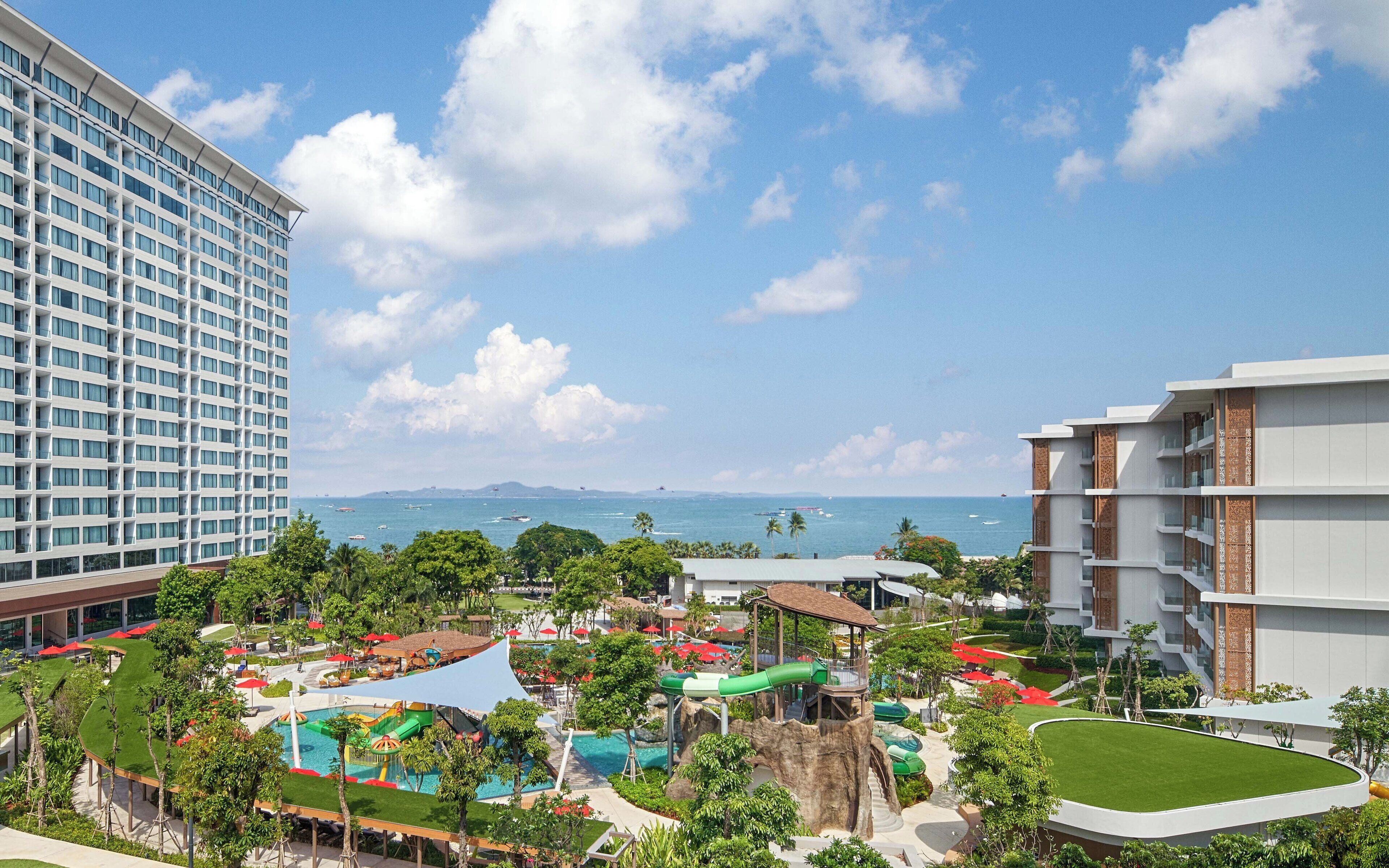 Um resort com área de piscina, toboáguas e vista para o oceano.