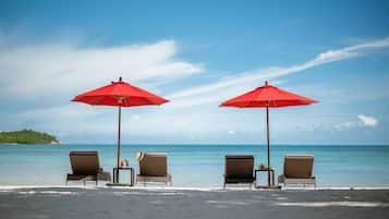 En la playa, playa de arena blanca, camastros y sombrillas