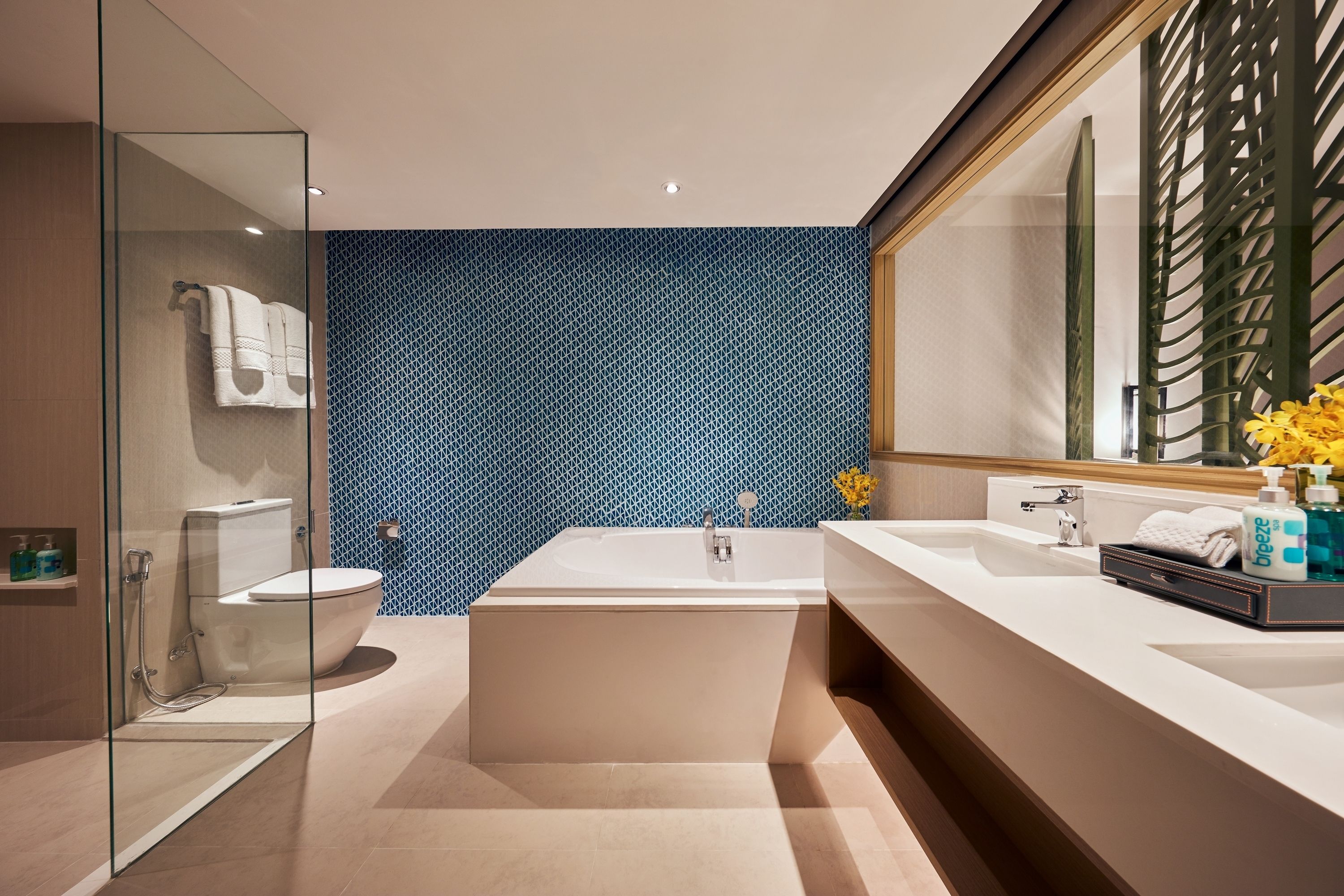 Une salle de bain moderne dotée d’une douche à parois de verre, d’une baignoire sur pieds et d’un meuble-lavabo avec un grand miroir.