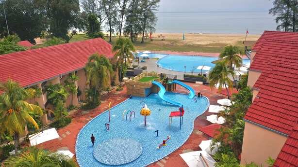A water park with multiple slides and pools, surrounded by palm trees and beach views. - Holiday Villa Beach Resort & Spa Cherating (Cherating)
