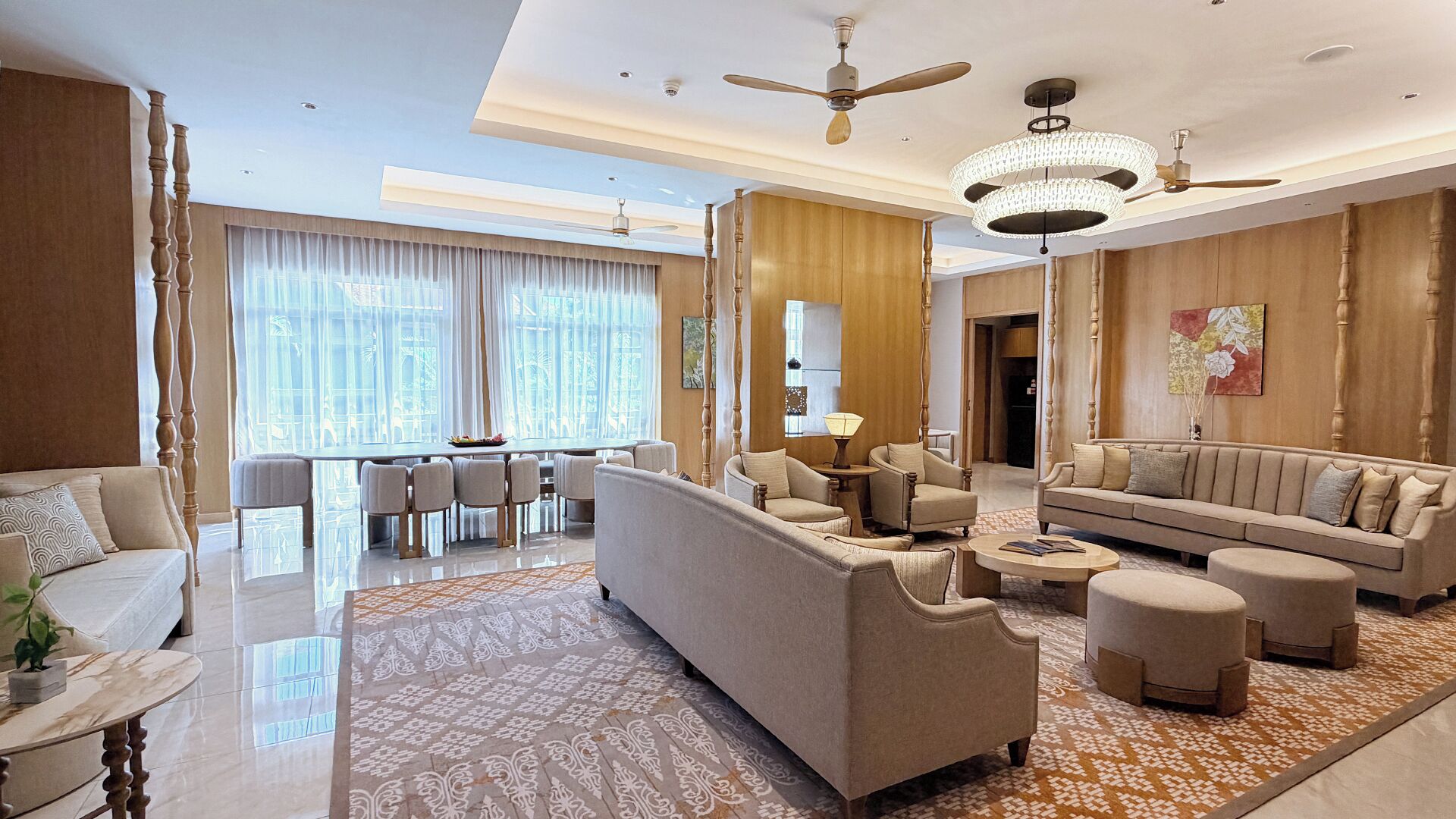 A spacious living area with a sofa, armchairs, a coffee table, and a dining table.
