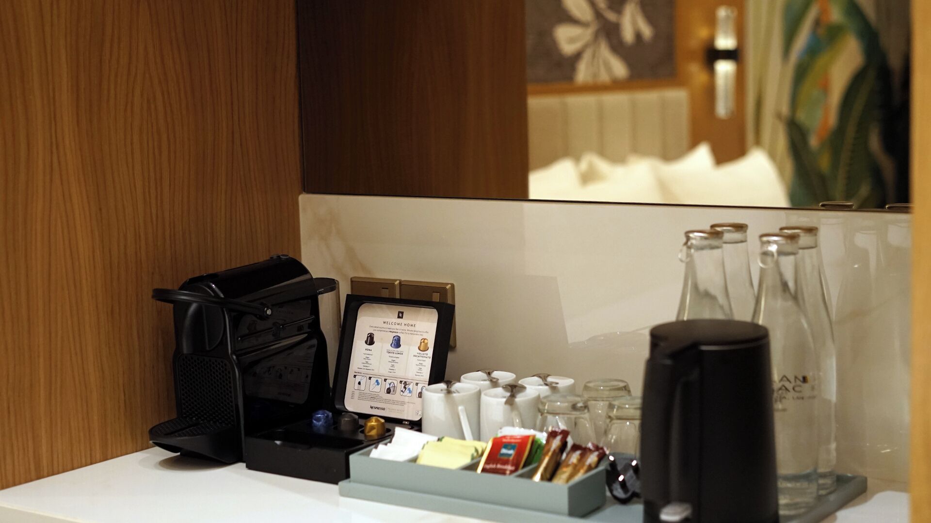 Ein Hotelrezeptionstresen mit einer Kaffeemaschine, einer Speisekarte und einer Ablage mit verschiedenen Artikeln.