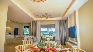 A modern hotel room with a balcony, a dining area, and a TV.