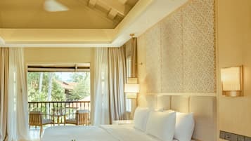 A hotel room with a large bed, a bedside table with a phone, a ceiling fan, and a view of the outdoors.