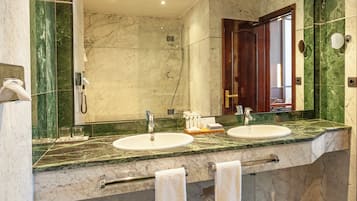 Ein Badezimmer mit zwei Waschbecken, einem großen Spiegel und einem Handtuchhalter.
