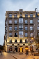 A multi-story hotel with balconies, large windows, and a central entrance.
