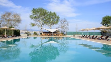 Una piscina techada, una piscina al aire libre de temporada, sombrillas