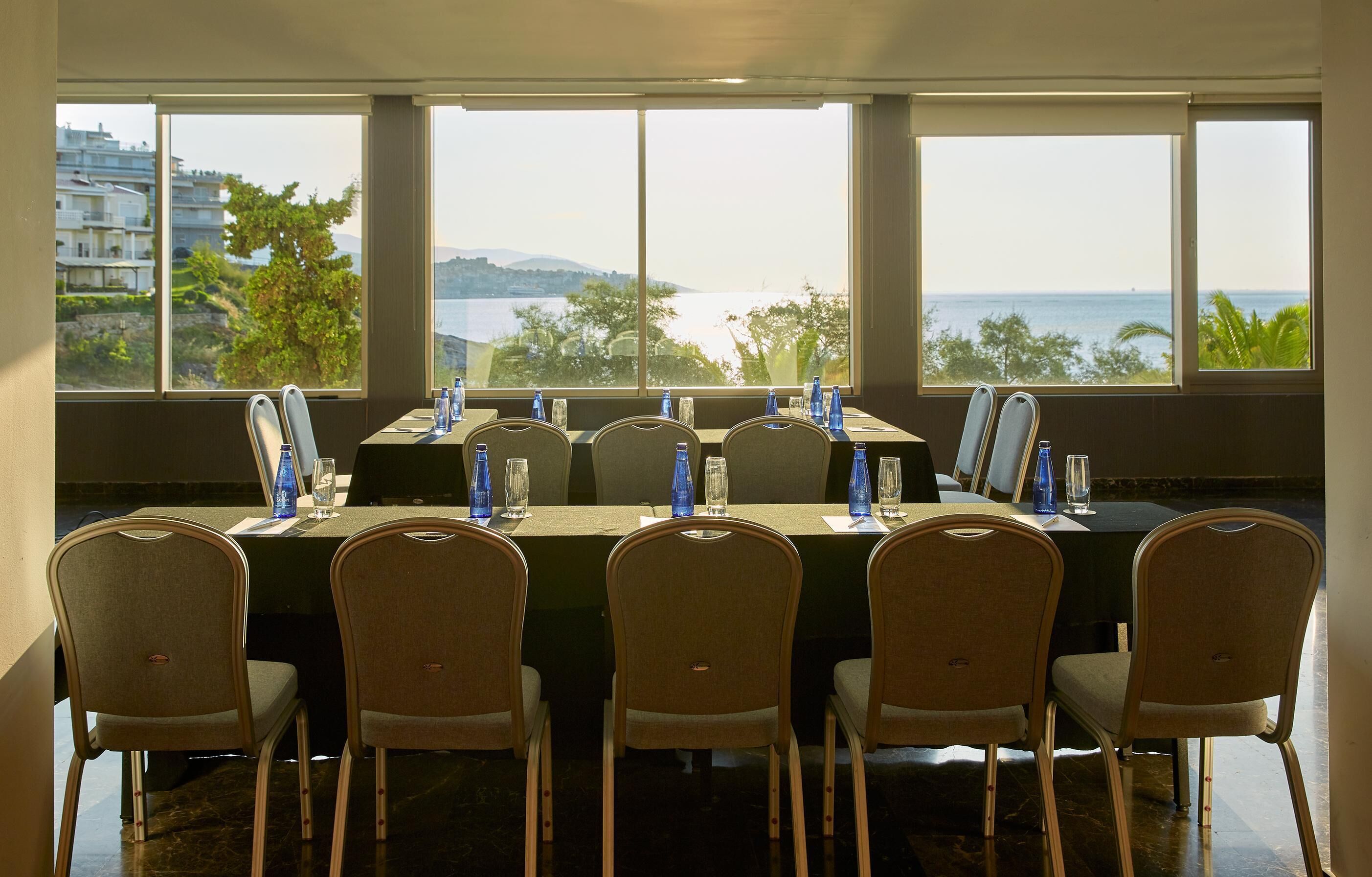 Una sala de conferencias con vista al mar y edificios.