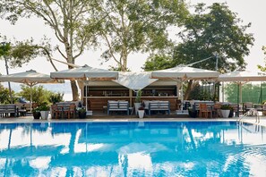Una piscina techada, una piscina al aire libre de temporada, sombrillas