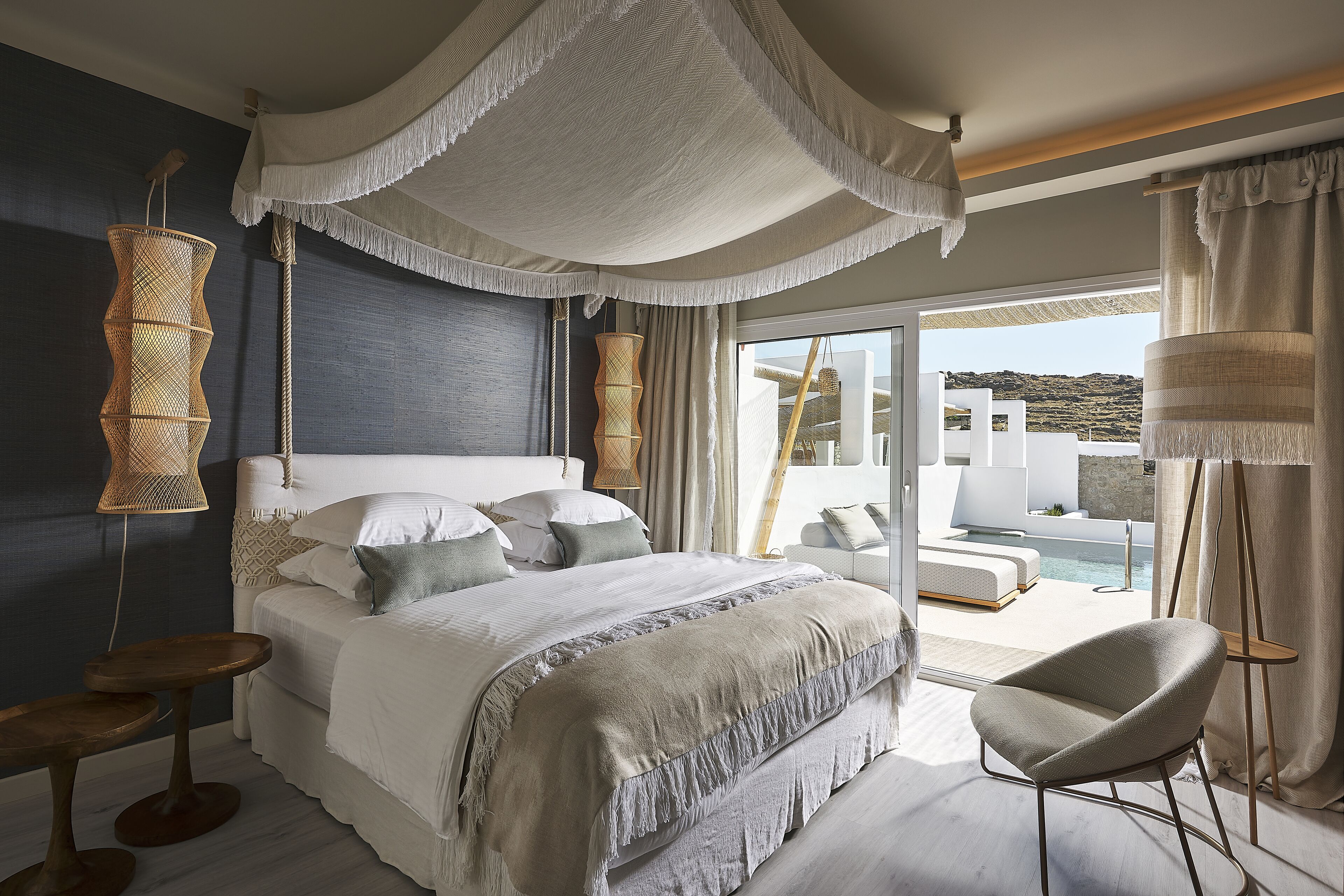 A bedroom with a large bed, a view of the pool, and a balcony.